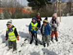 Děti si na sněhu hrají a dovádějí